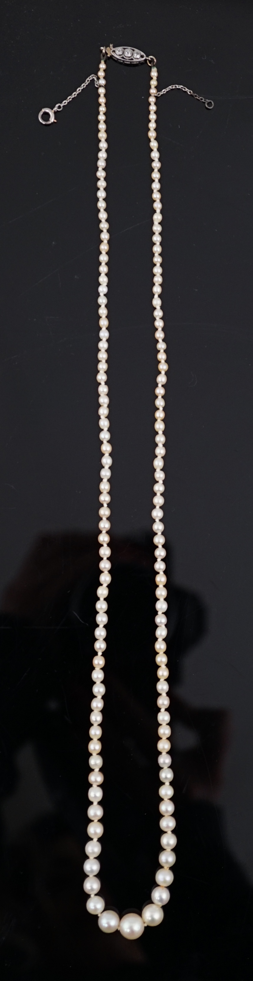 An early 20th century single strand graduated natural pearl and seed pearl necklace, with three stone diamond set clasp and Anchor Cert report dated 27/6/2014 stating an extensive sample to be natural pearls